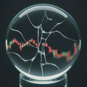 A stock chart behind a cracked crystal ball.